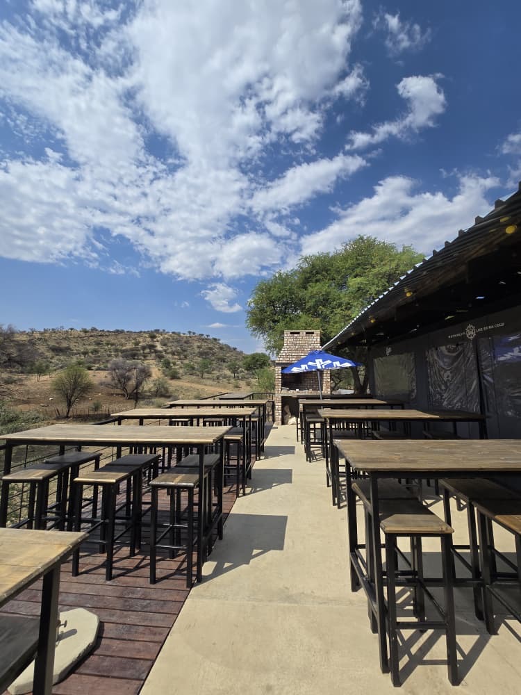High tables on the open-air terrace under a blue sky