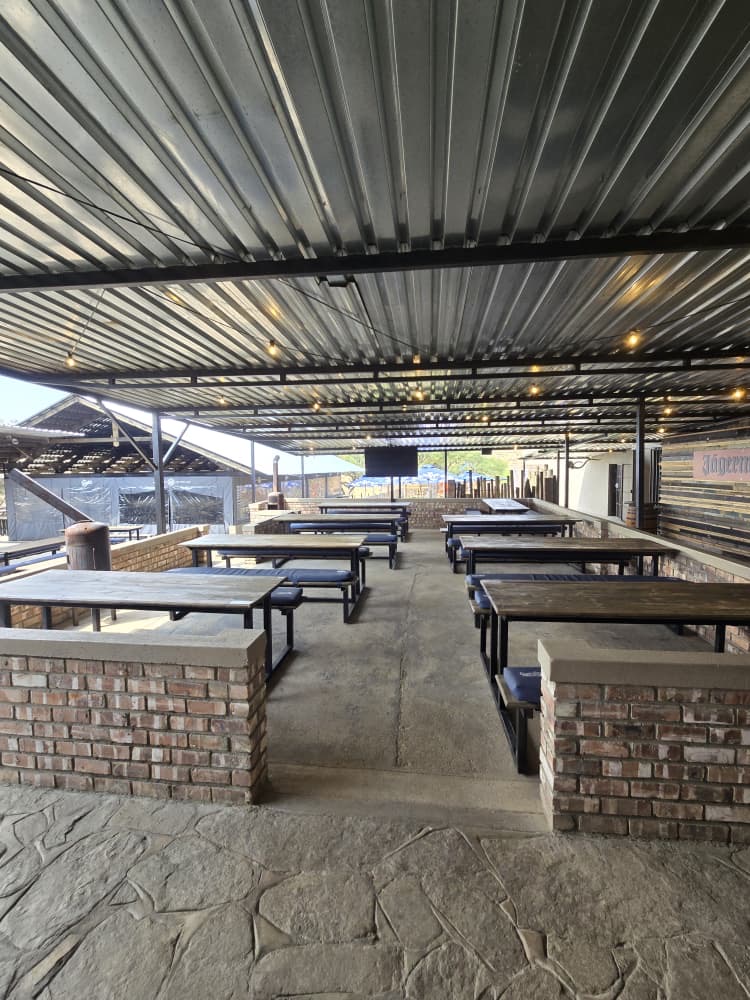 Covered seating area with brick walls and long tables before service