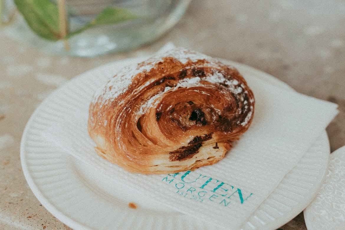 Pain au chocolat dusted with icing sugar on a Guten Morgen napkin