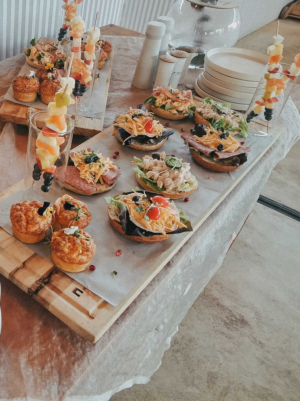 Grazing board of open sandwiches, quiches and fruit skewers