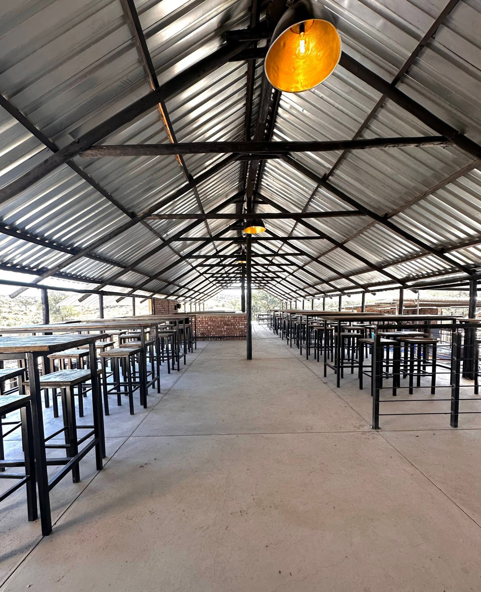 Warm pendant lamp glowing above the empty tables in the undercover hall