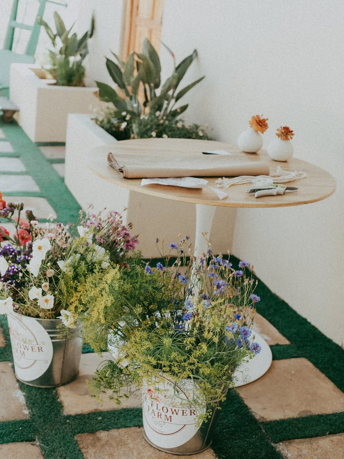 Flower Bar wrapping table with brown paper, snips and buckets of cornflowers