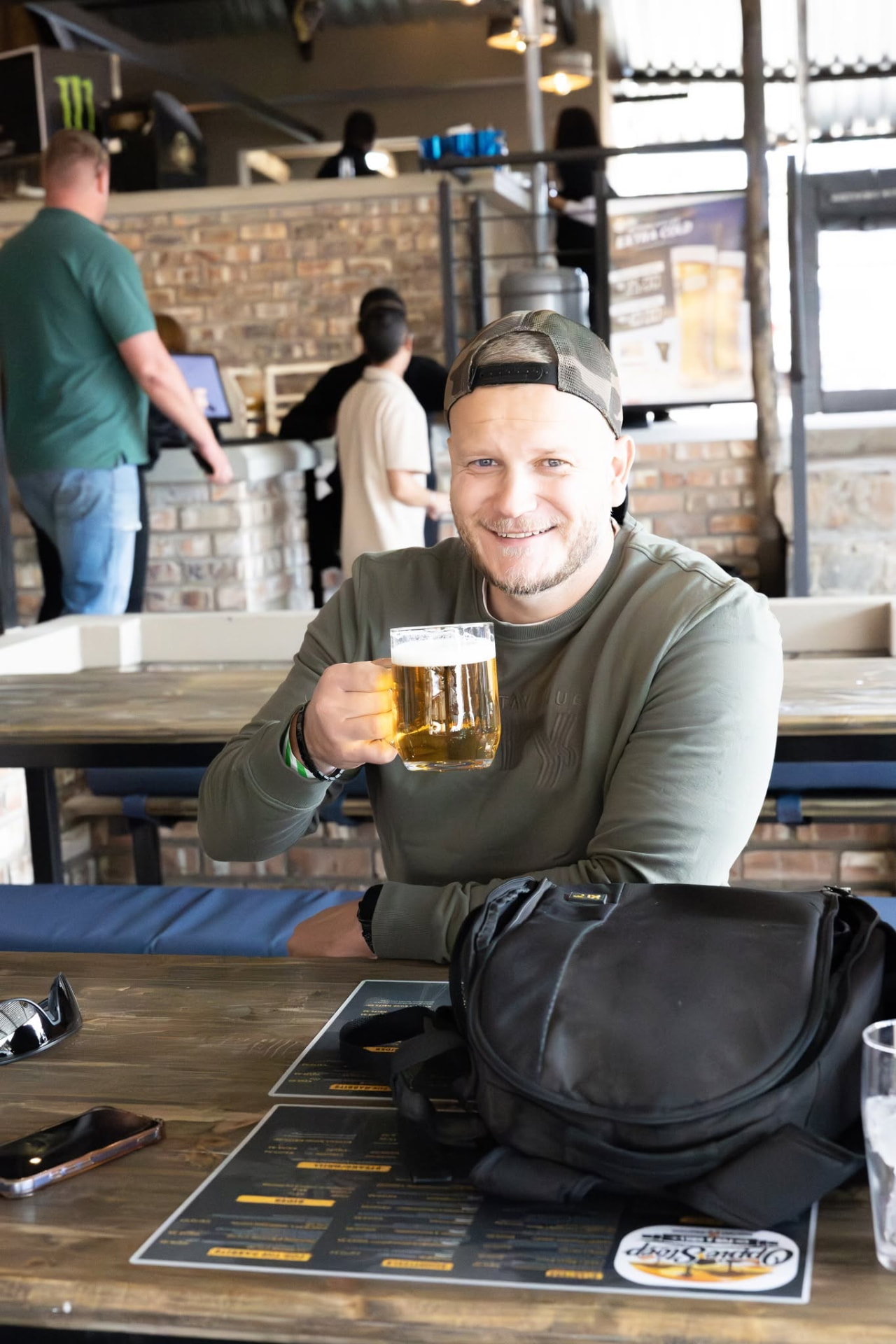 Guest raising a cold beer at the bar counter