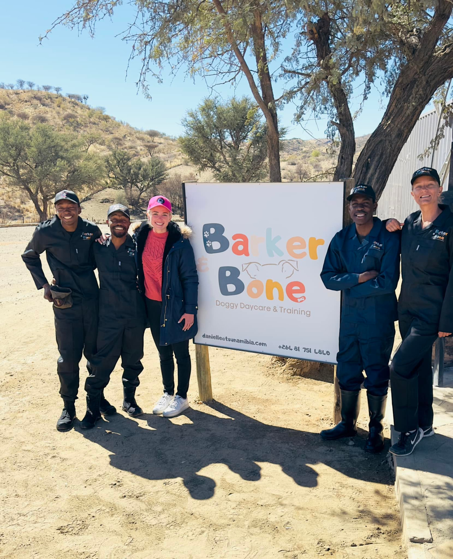 The Barker & Bone team standing together at the entrance sign