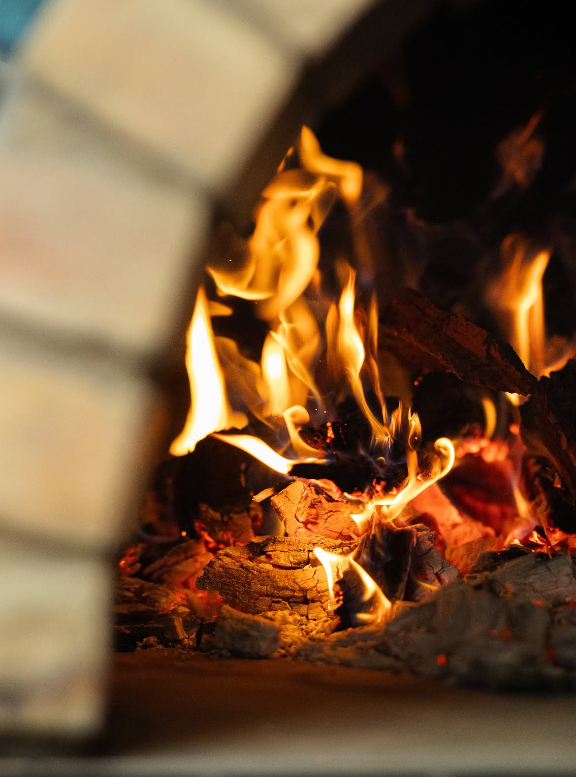 Flames and coals burning inside the wood-fired oven