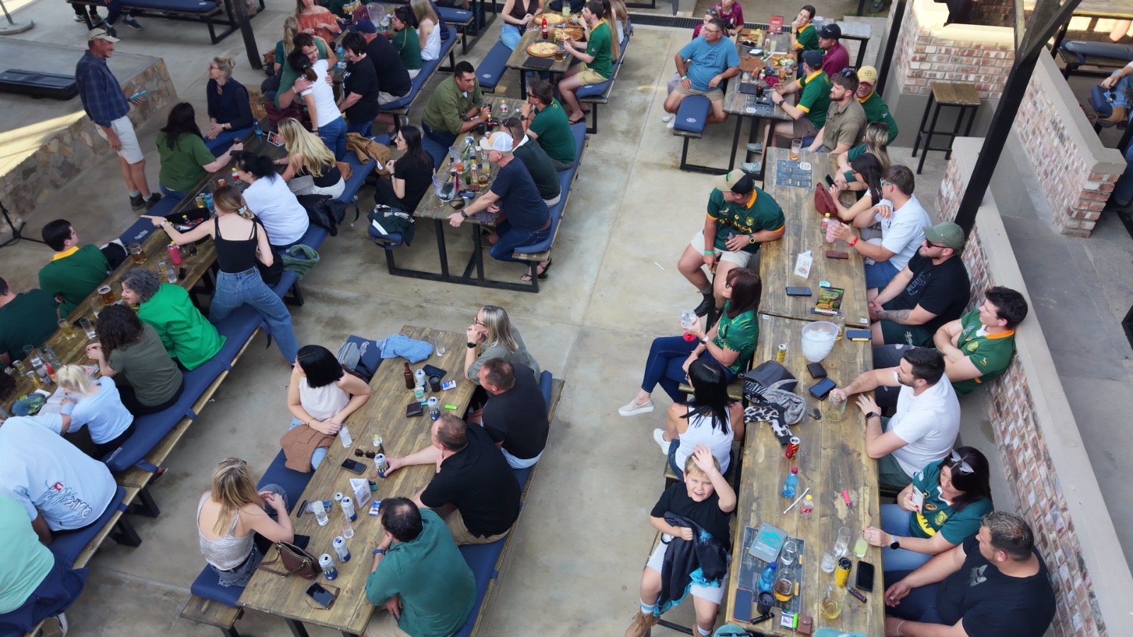 Long wooden tables filled with guests seen from above