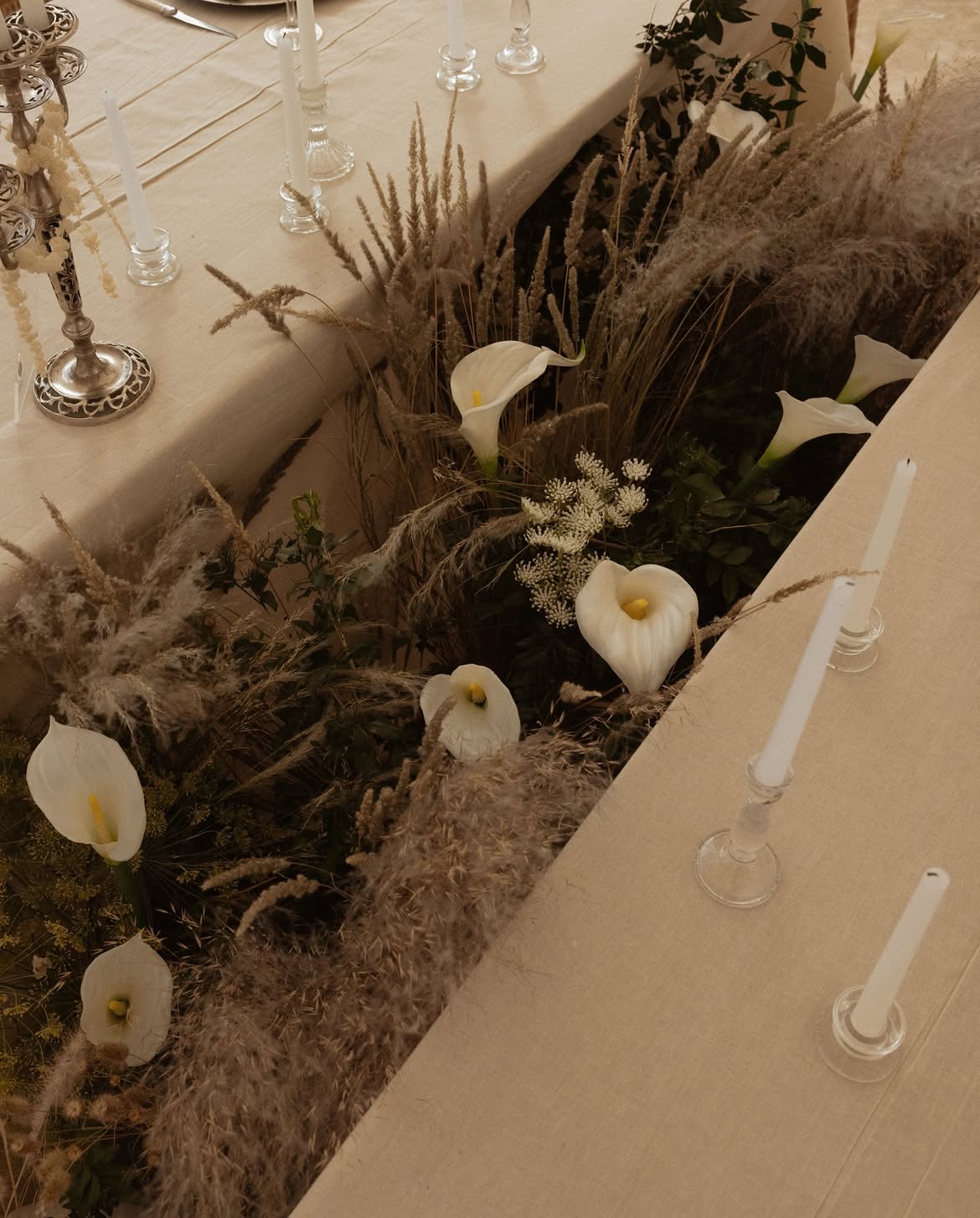 Calla lilies and pampas grass running down the centre of the table