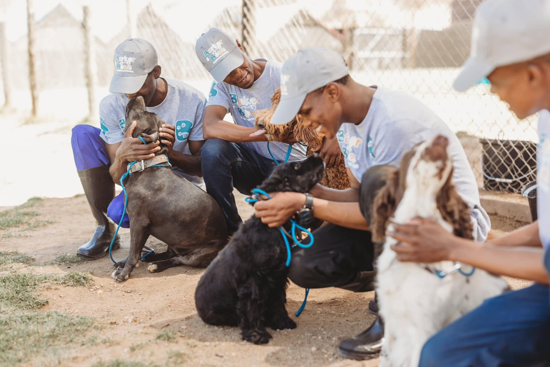 Barker & Bone team members sitting with dogs on lead